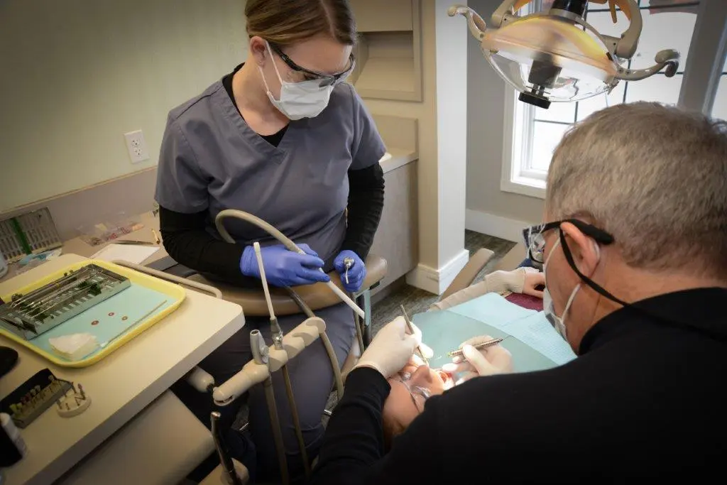 Dr. Gardner working on a patient with staff assisting- photo angled from doctor closer image