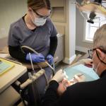 Dr. Gardner working on a patient with staff assisting- photo angled from doctor closer image