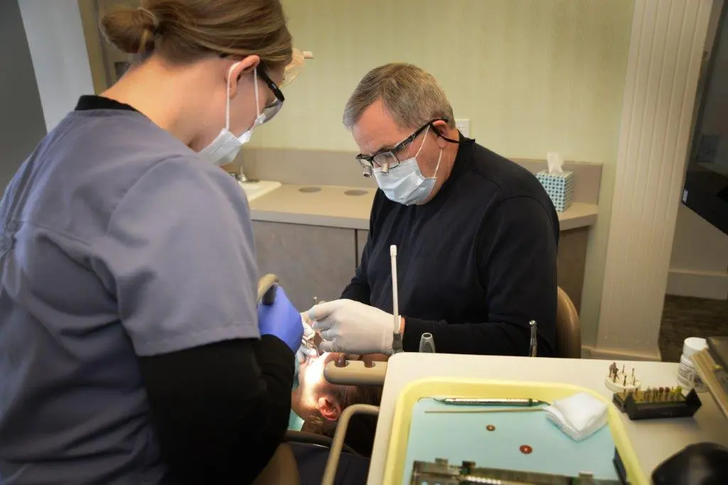 Dr. Gardner working on a patient with staff assisting - photo angled from staff