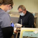 Dr. Gardner working on a patient with staff assisting - photo angled from staff