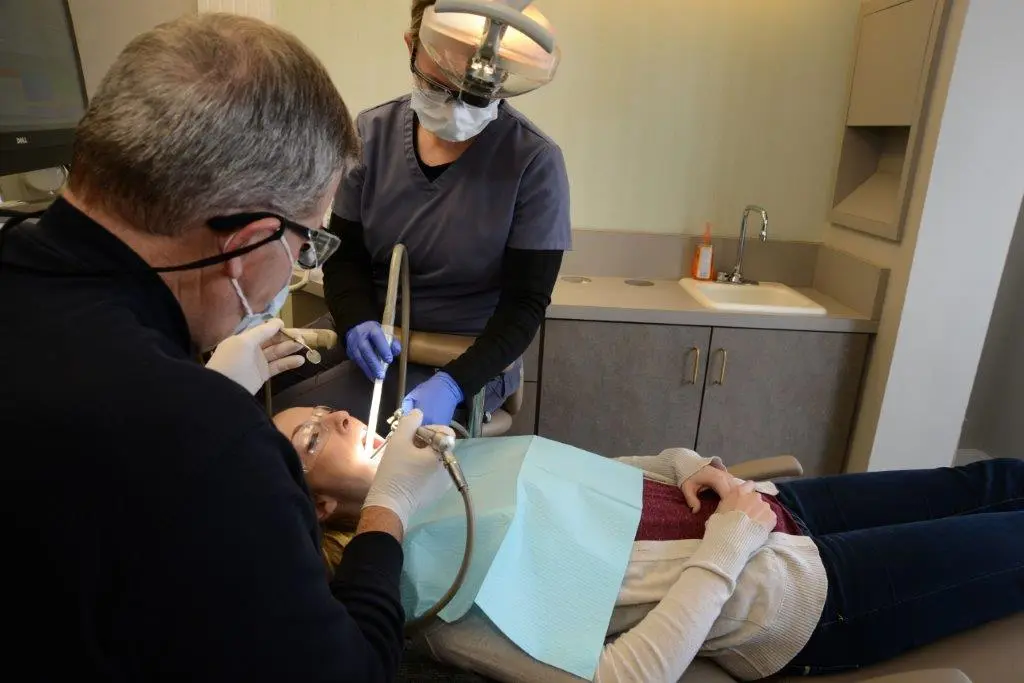 Dr. Gardner working on a patient with staff assisting- photo angled from doctor